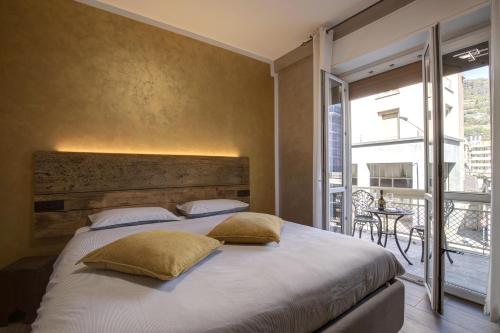 Un dormitorio con una cama grande y un balcón. en LA LUPA Apartment - In the heart of Aosta with car Box, en Aosta