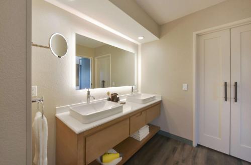 a bathroom with two sinks and a large mirror at Hyatt Centric Santa Clara Silicon Valley in Santa Clara