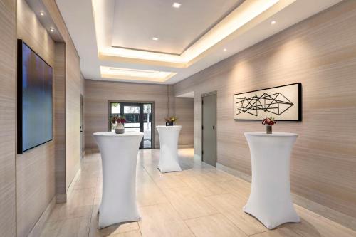 a hallway with three white stools in a room at Hyatt Centric Santa Clara Silicon Valley in Santa Clara