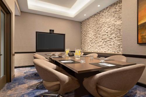 a conference room with a table and chairs and a tv at Hyatt Centric Santa Clara Silicon Valley in Santa Clara