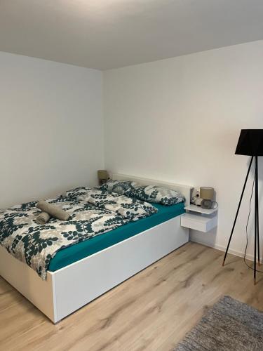 een slaapkamer met een bed met een zwart-wit dekbed bij Apartment VBK Osijek in Osijek