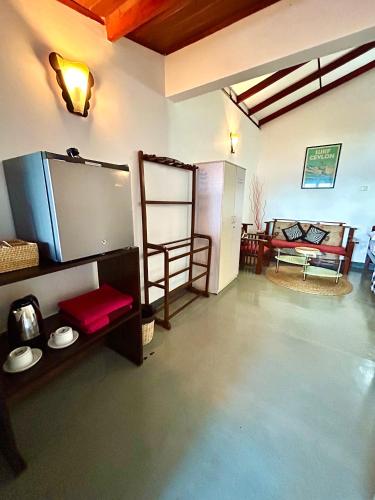 a living room with a flat screen tv and a couch at Kenno's Korner in Weligama