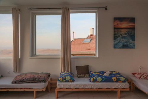 a room with two beds and a large window at רוג'ום גסטהאוס Rujum in Arad