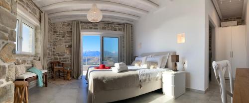 een slaapkamer met een bed en een groot raam bij VILLA LEVANTA - Das ideale Wohlfühl-Refugium Aussicht, Komfort, Erholen, Home Office in Pitsidia