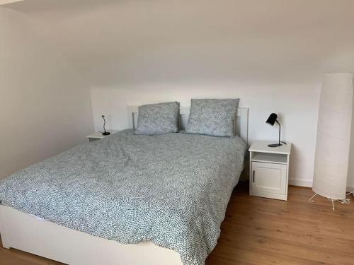 Un pat sau paturi într-o cameră la Duplex sur le port du Croisic