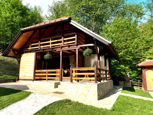 a small log cabin with a porch and grass at Kuca za odmor Marjanovic in Gornji Milanovac