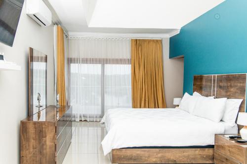 Un dormitorio con una cama grande y una pared azul. en Elim Lakeside House, en Elim