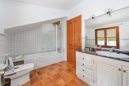 uma casa de banho com uma banheira, um lavatório e um espelho. em Villa Eu Figueral by JS Villas em Port de Pollença