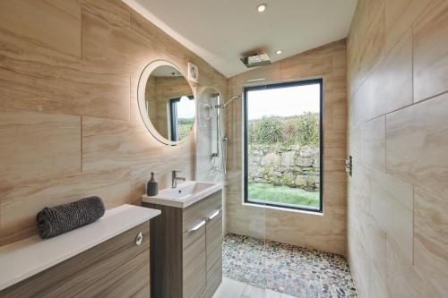een badkamer met een wastafel en een spiegel bij Family Friendly, self contained, Bed and Breakfast with private hot tub in Laugharne