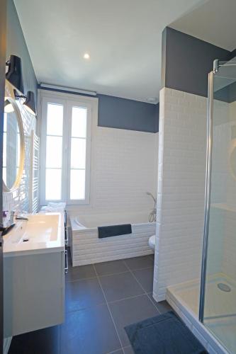 une salle de bain avec une baignoire, un lavabo et une douche dans l'établissement Casa Bella, à Saint-Georges-de-Didonne