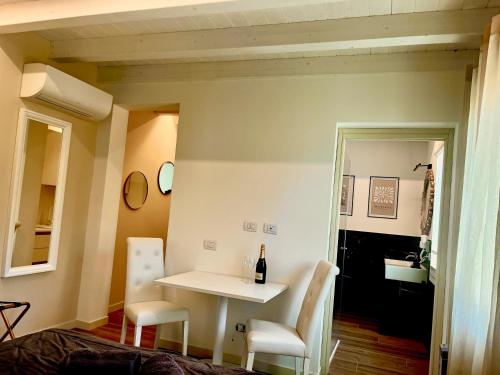 Habitación con mesa, sillas y botella de vino. en Star Soave Rooms - Locazione Turistica, en Soave