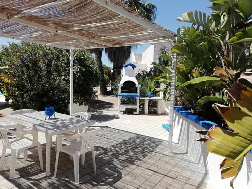 a patio with a table and chairs and a grill at Sole&Mare in Monopoli