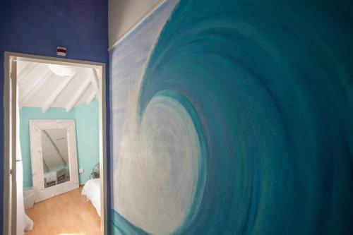 a room with a painting of a wave on the wall at Ericeira Surf Camp in Ericeira