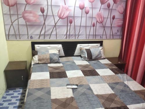 - une chambre avec un lit et une couverture en damier dans l'établissement OYO Home Safe In, à Rohtak