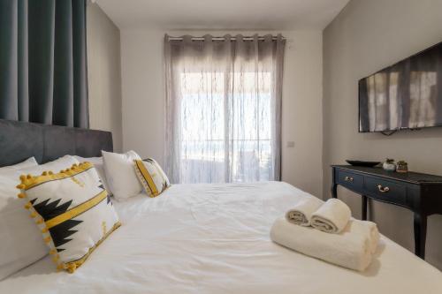 a bedroom with a large white bed with towels on it at Blue Lagoon Achziv Vacation in Nahariyya