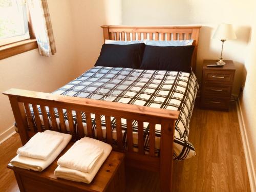 a bedroom with a wooden bed with two white towels at Invermac House in Inverness