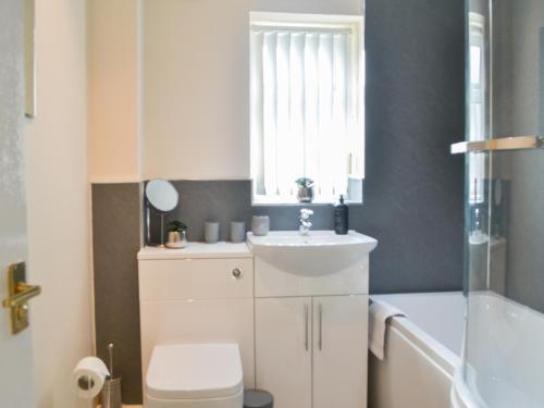 a bathroom with a sink and a toilet and a tub at Filey Central Two - Uk42903 in Filey