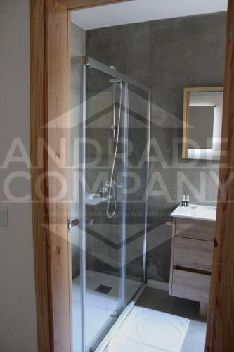 a glass shower in a bathroom with a sink at Casa da Padaria Antiga 1 in Pinhão