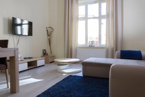 um quarto branco com uma cama, uma mesa e uma televisão em Bryza - apartament w Sopocie by Grand Apartments em Sopot