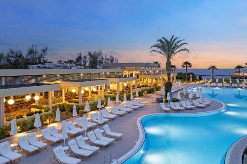 a hotel with a pool and lounge chairs and a resort at Liberty Hotels Lara in Lara