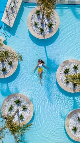 a woman in a swimming pool at a resort at Liberty Hotels Lara in Lara