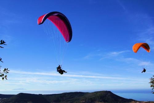 a group of people riding on parachutes in the sky at Hotel La Tartaruga Bianca in Valledoria