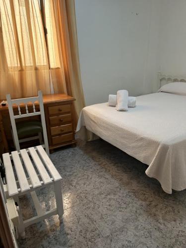 1 dormitorio con cama, silla y escritorio en Pensión Las Palmas, en Carboneras