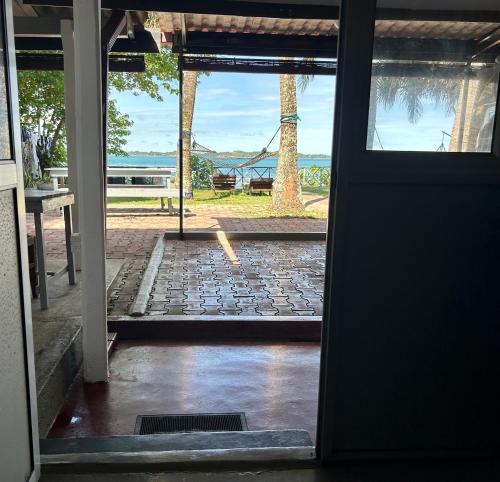 an open door with a view of the ocean at Kenno's Korner in Weligama