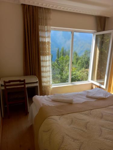 a bedroom with a bed and a large window at Guest House IRAKLI in P'ari