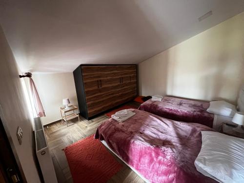 - une chambre d'hôtel avec 2 lits et un tapis rouge dans l'établissement Lovely and cozy 1-bedroom house with a sunny patio, à Korçë