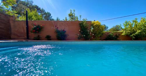 una piscina con acqua blu in un cortile di Villa Belephant Sitges a Canyelles