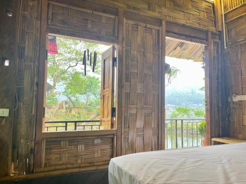 Sapa Bamboo Eco في سابا: غرفة نوم بسرير ونافذة كبيرة