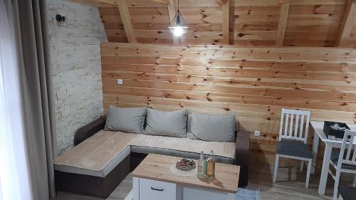 a room with a wooden wall with a couch and a table at House Bojana in Žabljak