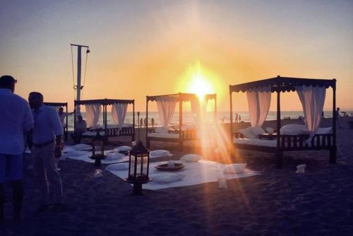 a group of beds on the beach at sunset at Casa Levante Fregene, mare e relax vicino Roma in Fregene