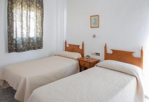 a room with two beds and a window at Pensión Las Palmas in Carboneras