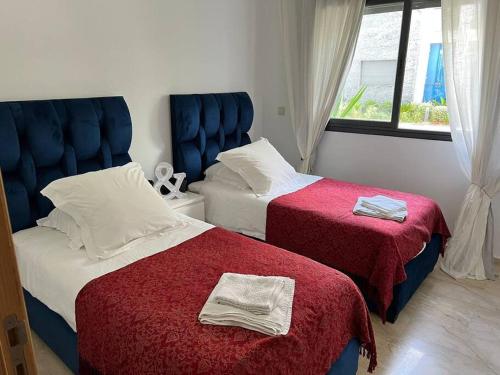 een slaapkamer met 2 bedden met rode en witte lakens bij BM Resort in Casablanca