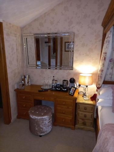a bedroom with a desk and a bed and a mirror at Virginia Cottage Guest House in Bowness-on-Windermere