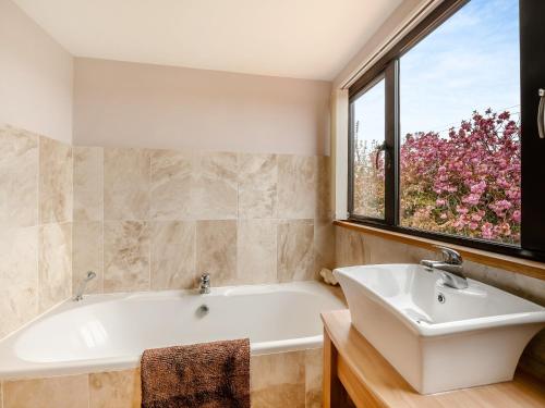 a bathroom with a tub and a window at Highfields in Runswick