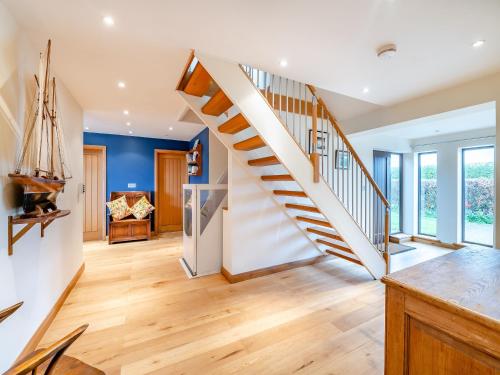 a staircase in a home with blue walls and wooden floors at Highfields in Runswick