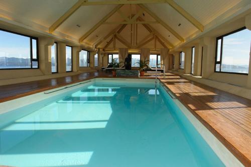 a large swimming pool in a house with windows at Hotel Panamericano Bariloche in San Carlos de Bariloche