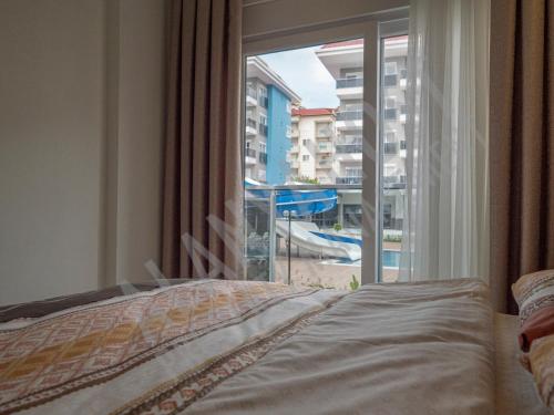 阿拉尼亞的住宿－Calypso Residence in Kestel Alanya E4，一间卧室设有享有泳池景致的窗户