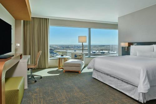 um quarto de hotel com uma cama e uma grande janela em The Westin Denver International Airport em Denver