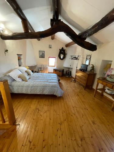 une chambre avec un lit et un parquet dans l'établissement L’aire vieille, à Pommiers