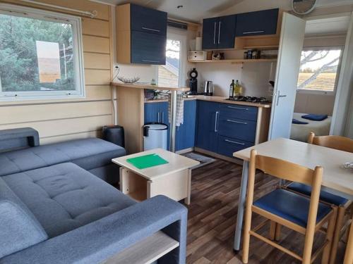 un salon avec un canapé et une table et une cuisine dans l'établissement les Lavandes dans le Luberon, à Brouville