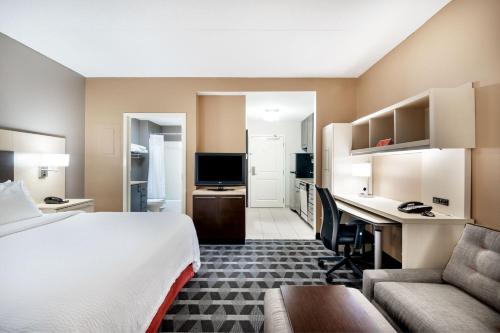 Habitación de hotel con cama y escritorio en TownePlace Suites by Marriott Charlotte Mooresville, en Mooresville
