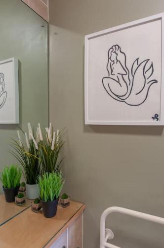 a bathroom with potted plants on a wooden cabinet at Pass the Keys Shoppers Oasis - Heart of Leeds City Centre in Leeds