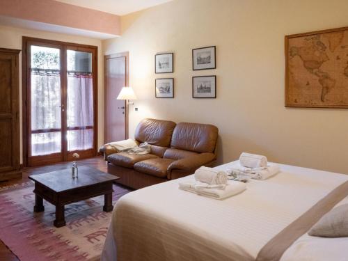 Habitación de hotel con 2 camas y sofá en B&B Casa Decimo, en Greve in Chianti