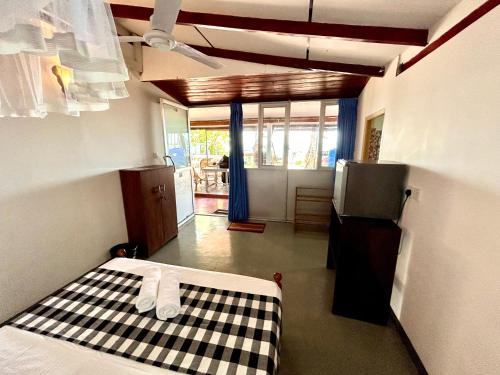 a room with a bed with a checkeredkered floor and a room with at Kenno's Korner in Weligama
