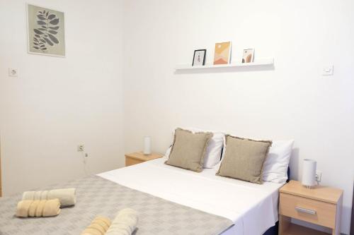 a bedroom with a large bed with white sheets and pillows at Vila Nada in Prigradica