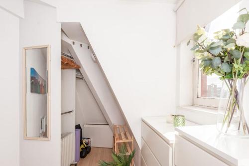 a room with a staircase with a vase of flowers at Pass the Keys Lovely apartment in Leeds centre in Leeds